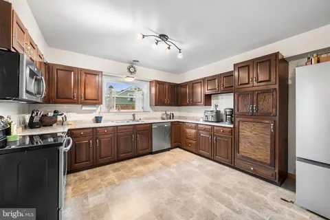 a kitchen with granite countertop a refrigerator stove top oven and sink