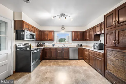a kitchen with stainless steel appliances granite countertop a stove cabinets a sink and a refrigerator
