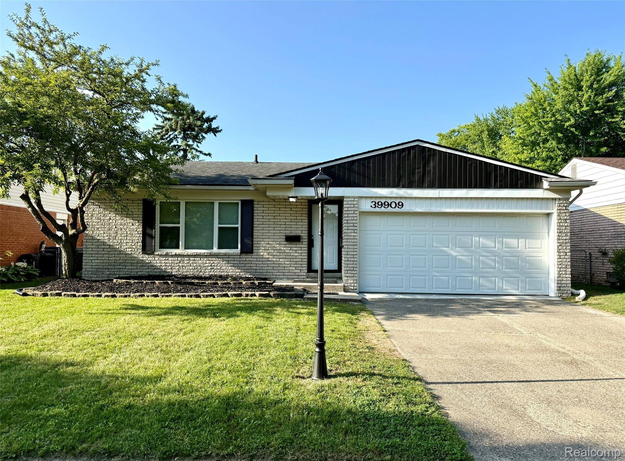 39909 Lynn Street Canton, MI 48187 - Photo 1 of 45 Ranch-style exterior featuring light-colored brick, a white paneled garage door, and a black shingle roof