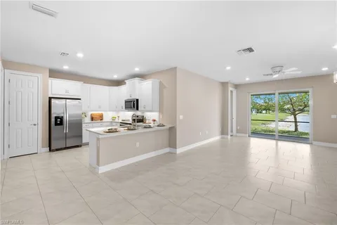 a large kitchen with a large counter top stainless steel appliances and cabinets