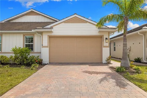 a front view of a house with a yard and potted plants