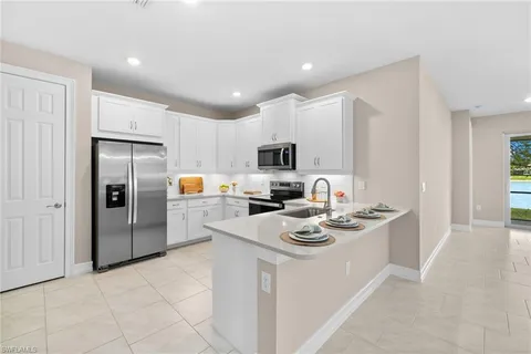 a kitchen with stainless steel appliances granite countertop a refrigerator stove microwave and sink
