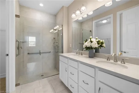 a bathroom with a double vanity sink mirror and shower