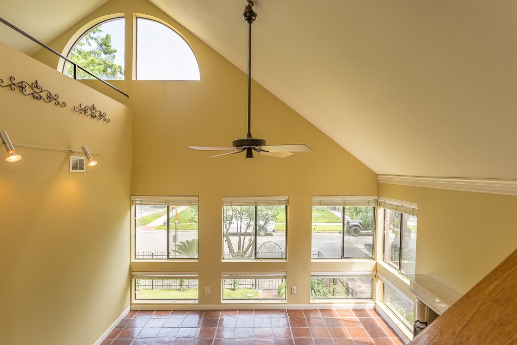 2349 Albans Road, Unit 2 Houston, TX 77005 - Photo 5 of 25 Gaze from the stairs into a sunlit living room with soaring ceilings and expansive windows, creating an inviting and airy ambiance.