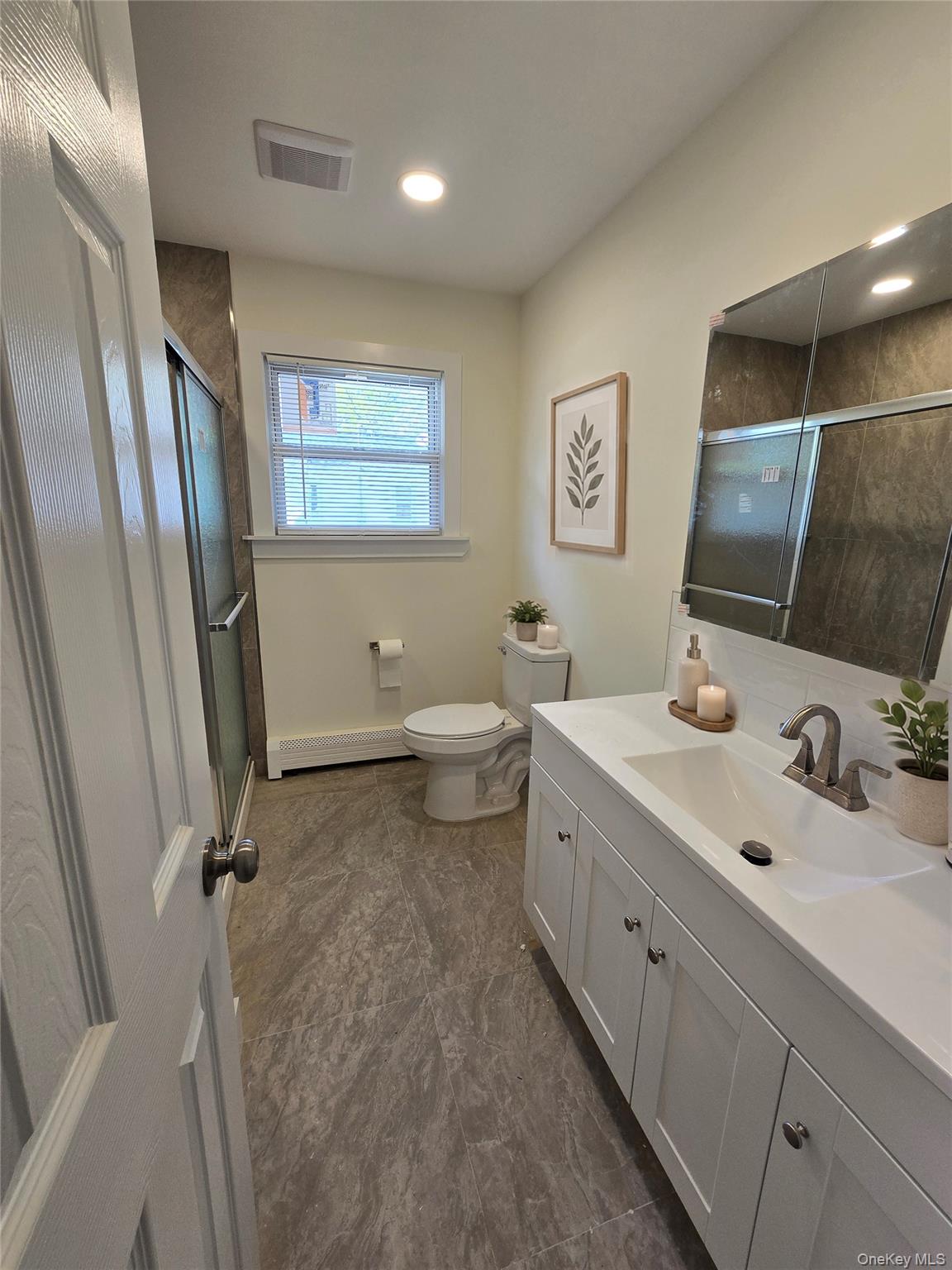 90 Blue Point Road Selden, NY 11784 - Photo 10 of 19 Bathroom featuring a white vanity with a single basin sink, brushed nickel faucet, large mirror, and recessed lighting