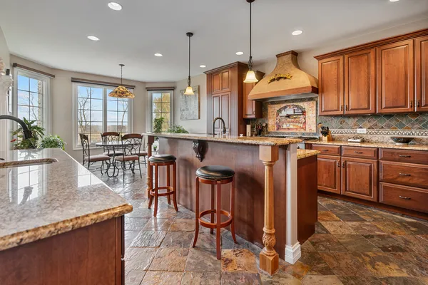 a kitchen with stainless steel appliances granite countertop a sink and a refrigerator