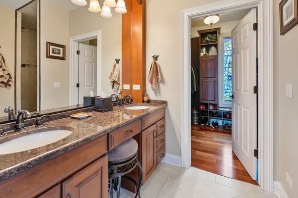 a bathroom with a granite countertop sink a mirror and a shower