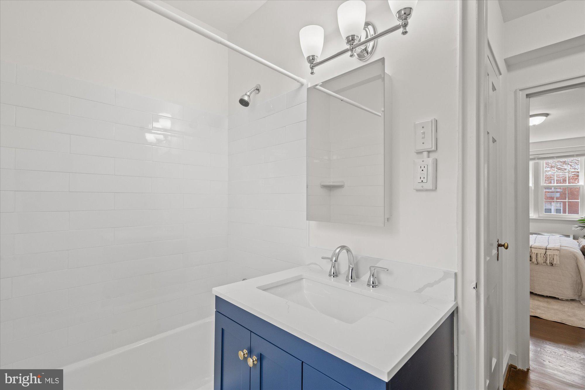 12 Ashby Street, Unit F Alexandria, VA 22305 - Photo 16 of 20 a bathroom with a sink vanity granite and shower