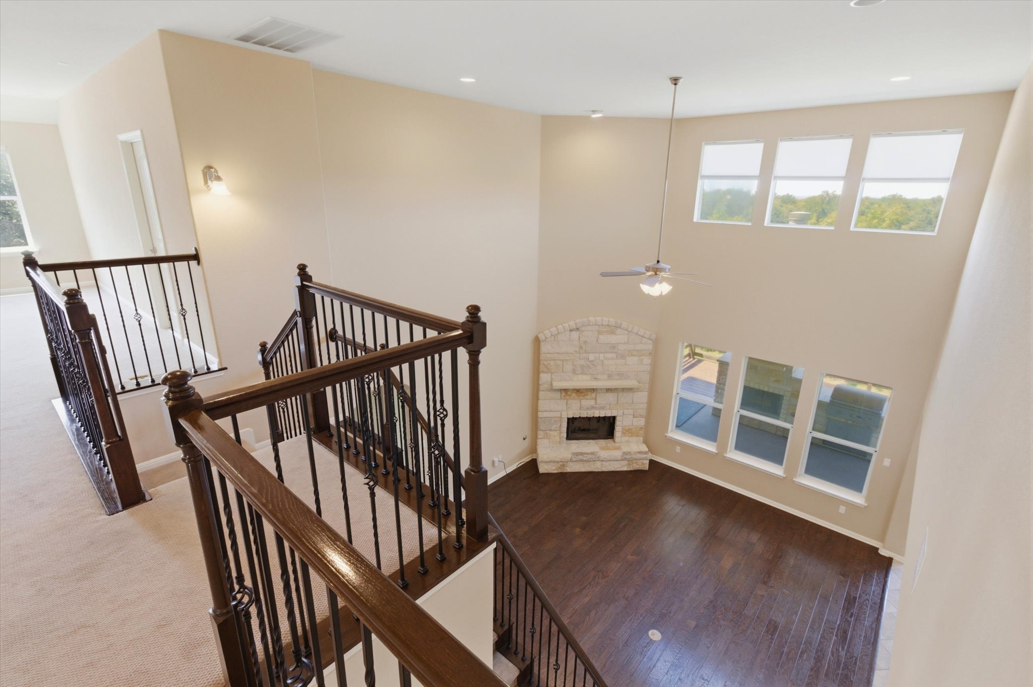 1511 Rimstone Drive Cedar Park, TX 78613 - Photo 14 of 39 A stone fireplace anchors this living space, offering warmth and charm with soaring ceilings and rich hardwood floors.