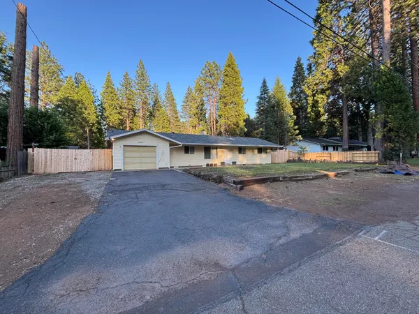 a view of a house with backyard and trees