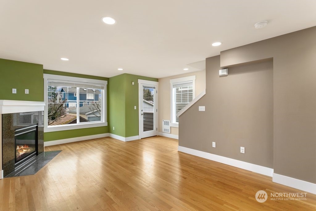 910 Northwest 85th Street, Unit A Seattle, WA 98117 - Photo 11 of 29 a view of an empty room with wooden floor and a fireplace