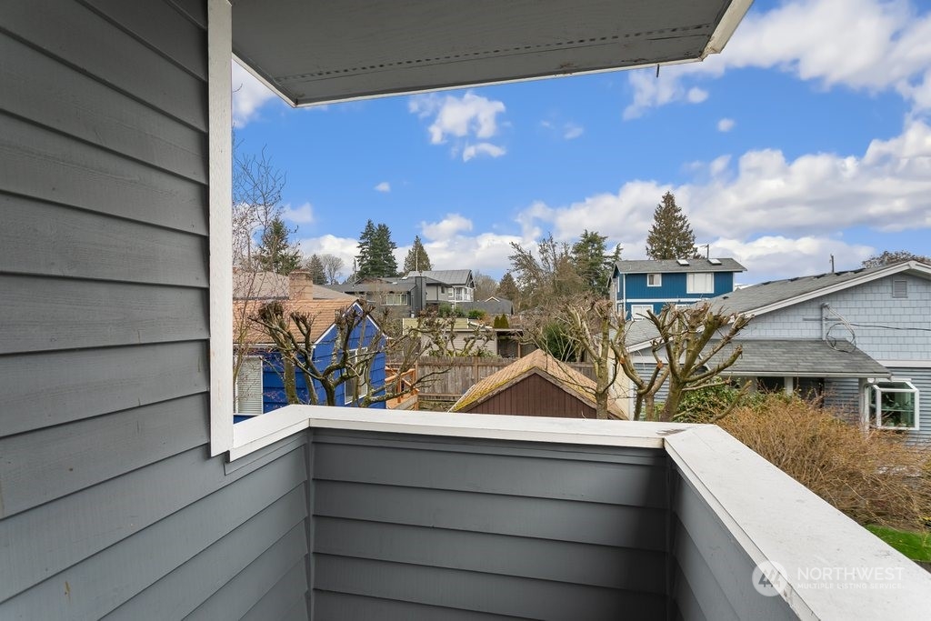 910 Northwest 85th Street, Unit A Seattle, WA 98117 - Photo 13 of 29 a view of a balcony with two plants and a barbeque