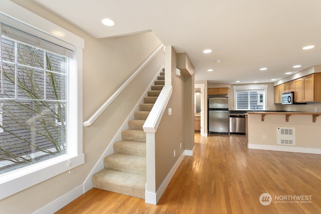 910 Northwest 85th Street, Unit A Seattle, WA 98117 - Photo 15 of 29 a view of a living room with wooden floor and windows