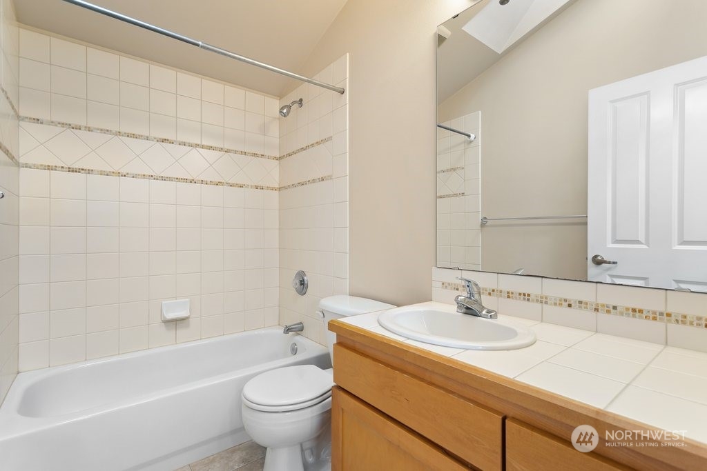 910 Northwest 85th Street, Unit A Seattle, WA 98117 - Photo 19 of 29 a bathroom with a sink a toilet and a bathtub