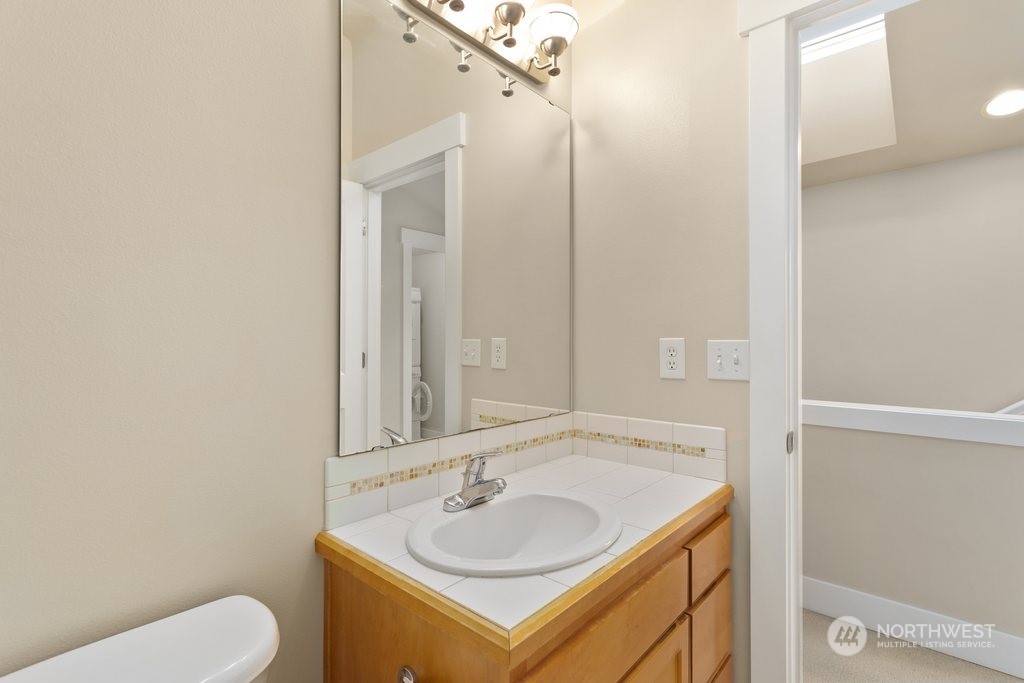 910 Northwest 85th Street, Unit A Seattle, WA 98117 - Photo 20 of 29 a bathroom with a toilet sink and mirror