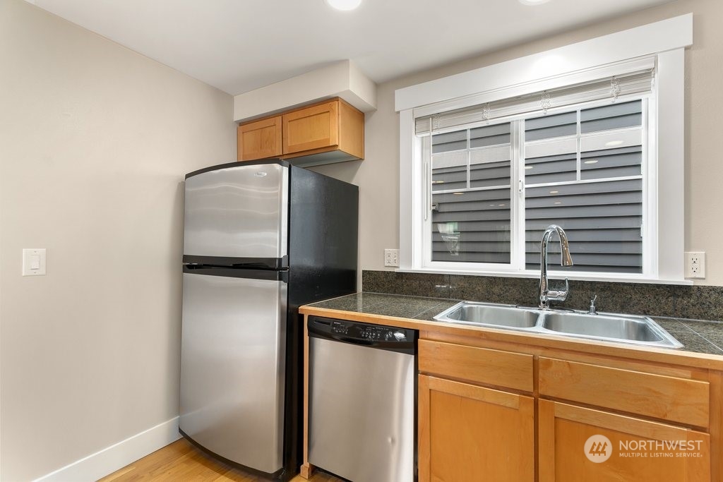 910 Northwest 85th Street, Unit A Seattle, WA 98117 - Photo 8 of 29 a kitchen with stainless steel appliances granite countertop a sink and a refrigerator