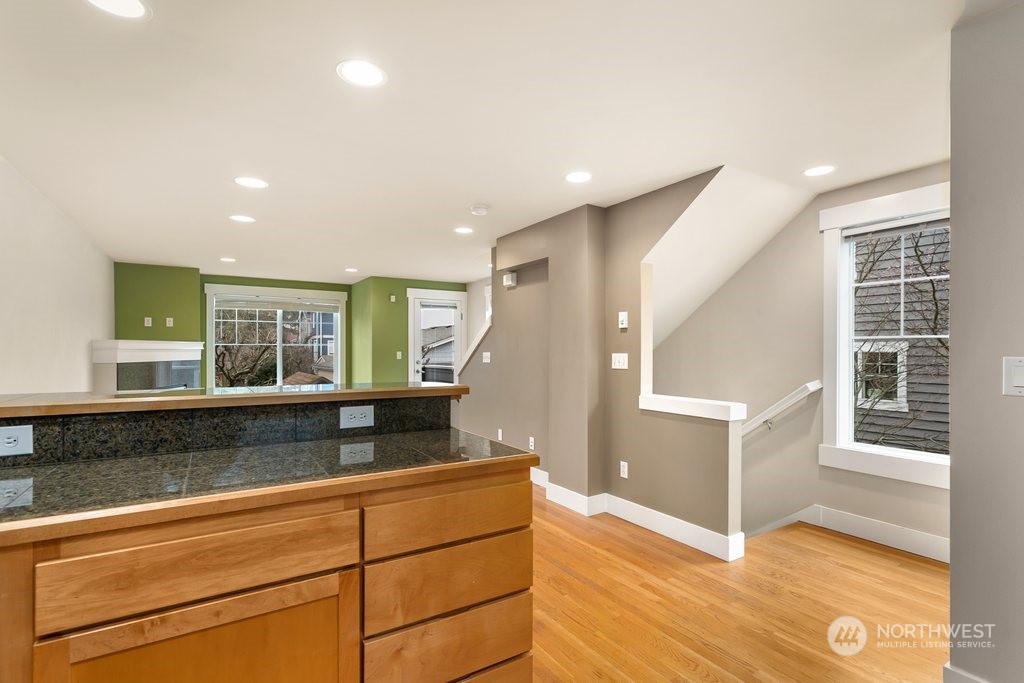 910 Northwest 85th Street, Unit A Seattle, WA 98117 - Photo 9 of 29 a living room with stainless steel appliances granite countertop furniture and a wooden floor