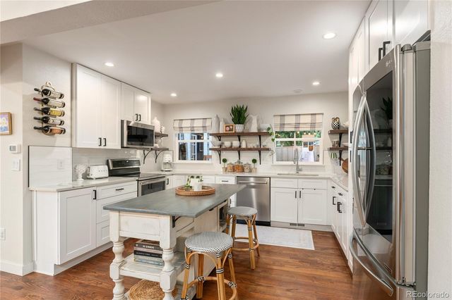 a kitchen with kitchen island appliances cabinets and chair