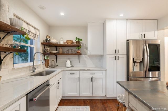 a kitchen with stainless steel appliances a sink a stove and a refrigerator