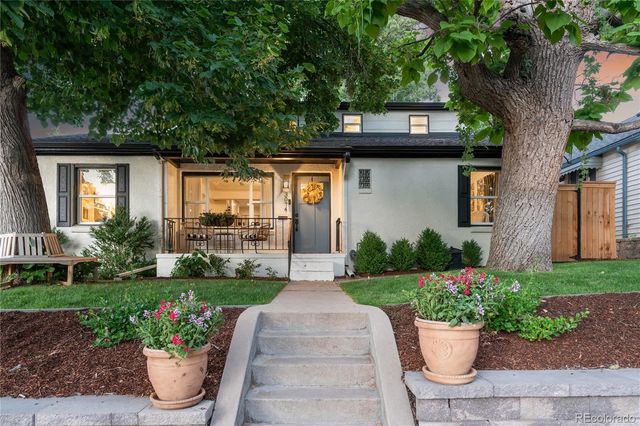 a front view of a house with a yard and potted plants