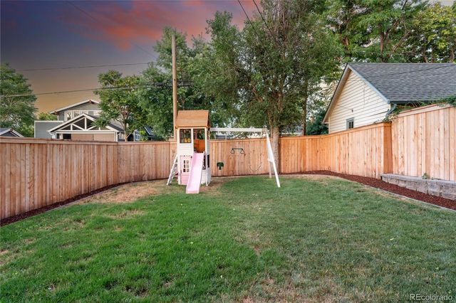 a view of a house with backyard and sitting area