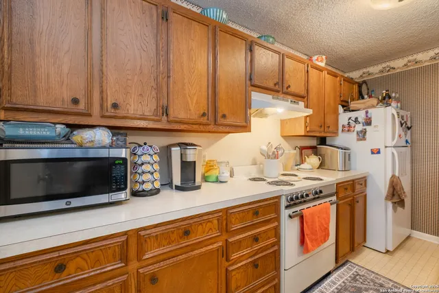 a kitchen with stainless steel appliances granite countertop a sink and a stove