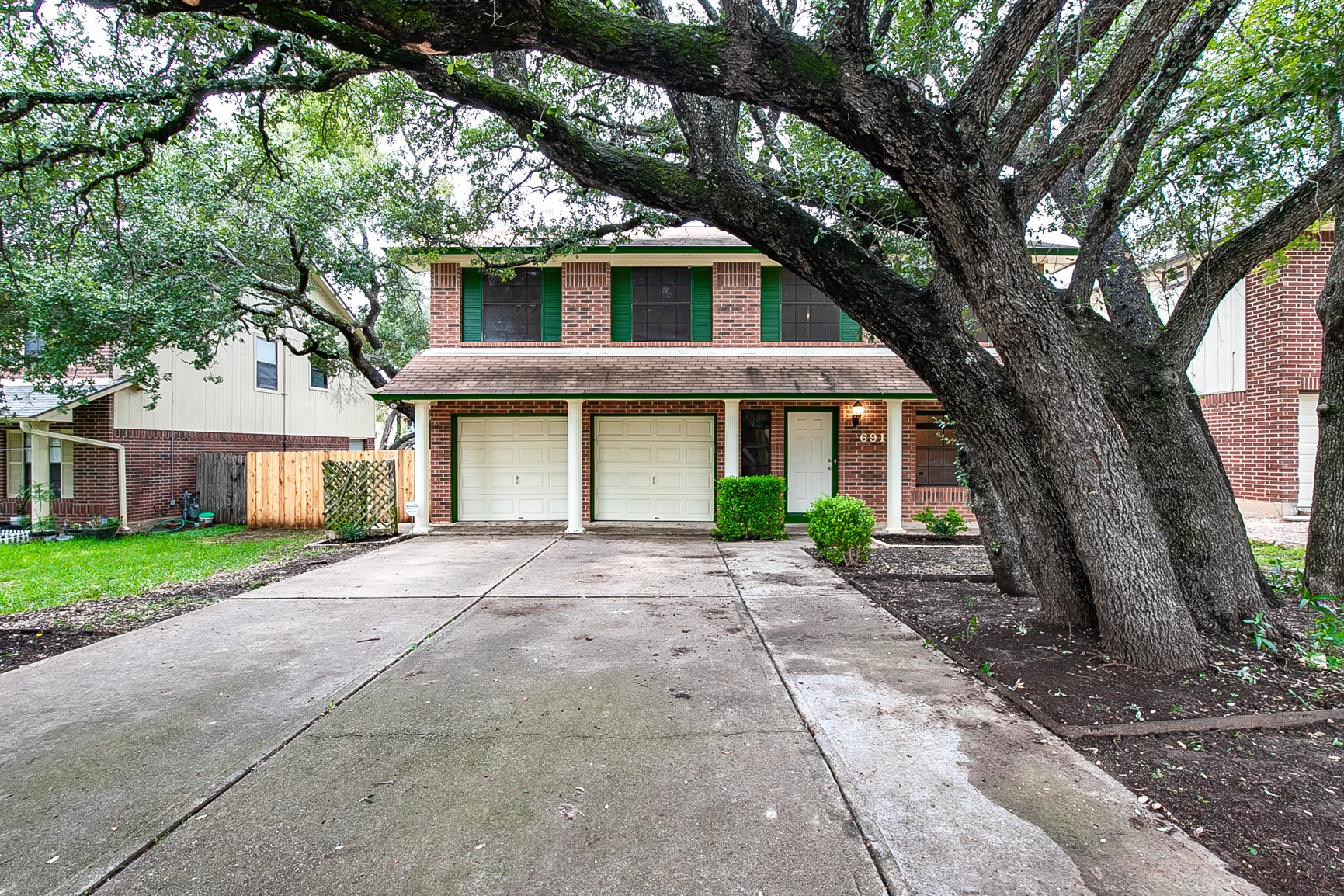 6914 Dallas Drive Austin, TX 78729 - Photo 1 of 31 a front view of a house with a garden and trees