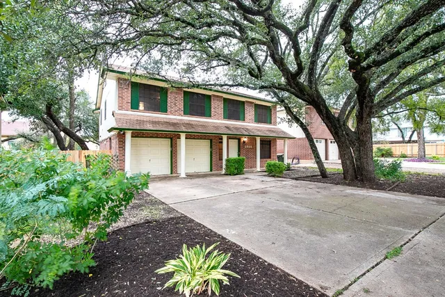 a front view of a house with a yard and trees