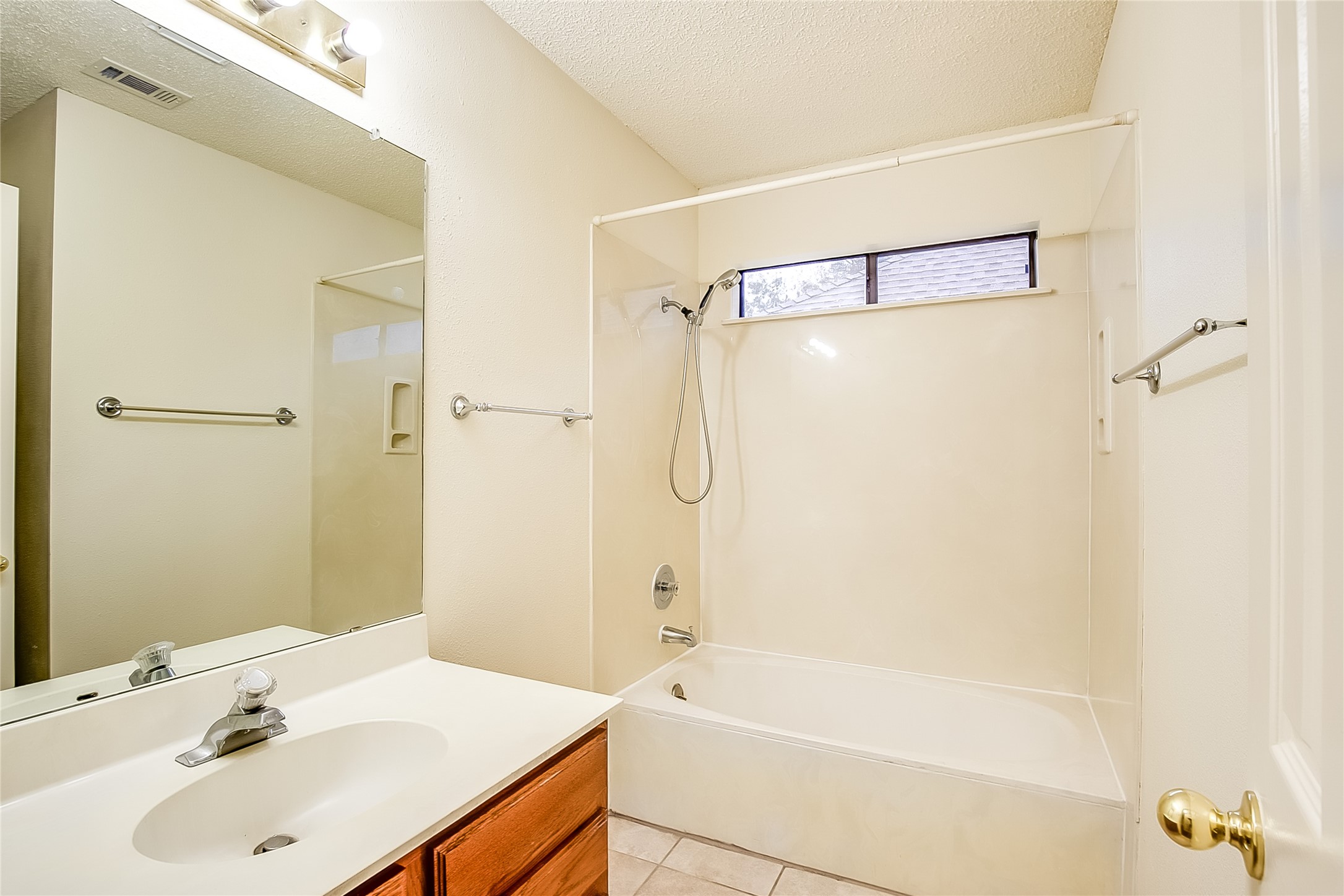 6914 Dallas Drive Austin, TX 78729 - Photo 26 of 31 a bathroom with a tub shower sink and a mirror