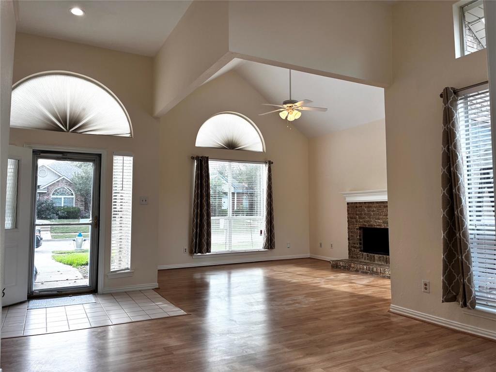 7936 Tournament Road Frisco, TX 75035 - Photo 2 of 28 a view of an empty room with wooden floor and a window