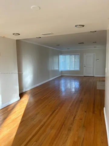 a view of an empty room and wooden floor