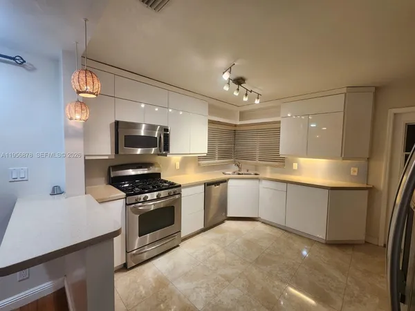 a large kitchen with a stove and a sink
