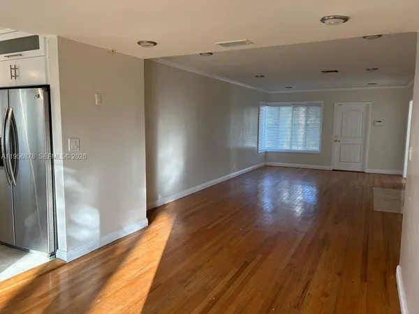 a view of a hallway with wooden floor and a cabinet