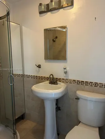 a bathroom with a toilet sink and mirror