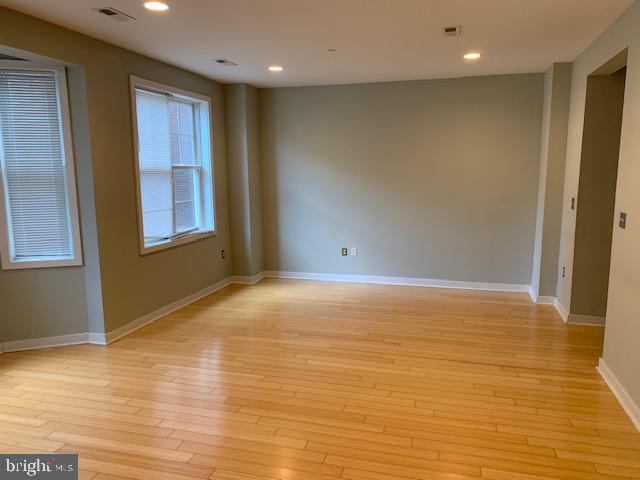 4742 Pine Street, Unit 104 Philadelphia, PA 19143 - Photo 5 of 12 a view of an empty room with wooden floor and a window