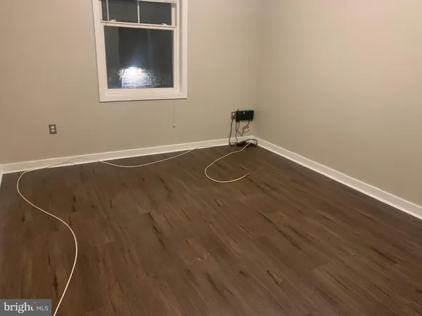 a view of a room with wooden floor and a window