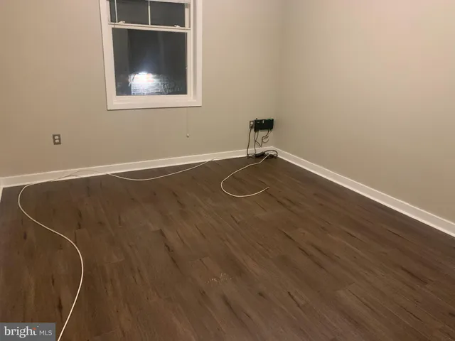 a view of a room with wooden floor and a window