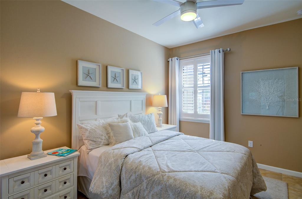12232 Marsh Pointe Road Sarasota, FL 34238 - Photo 26 of 44 a bedroom with a bed and a lamp on dresser