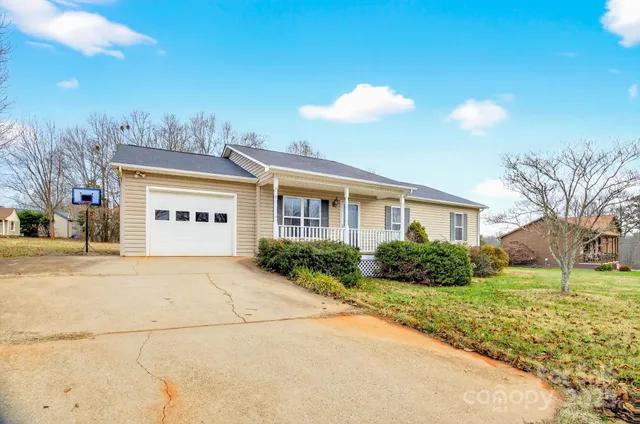 a view of a house with a yard and potted plants