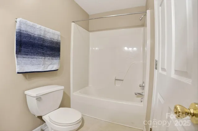 a white toilet sitting next to a bath tub shower