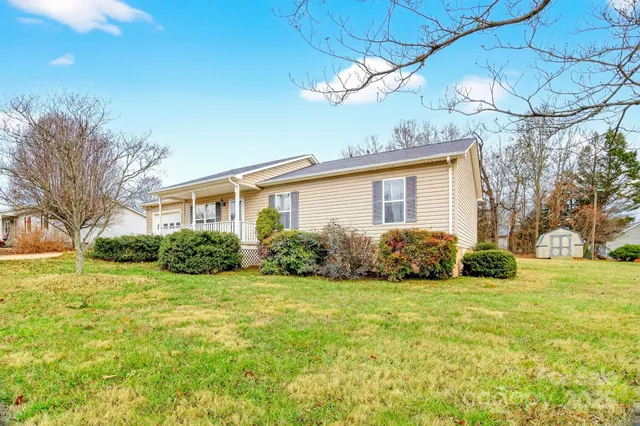 a view of a house with a big yard and large tree