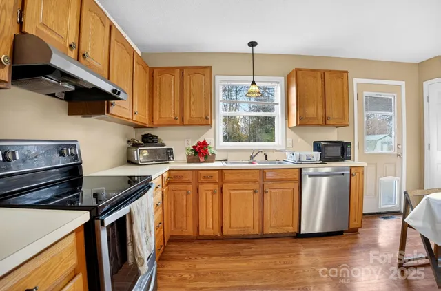 a kitchen with stainless steel appliances granite countertop a stove a sink and a refrigerator