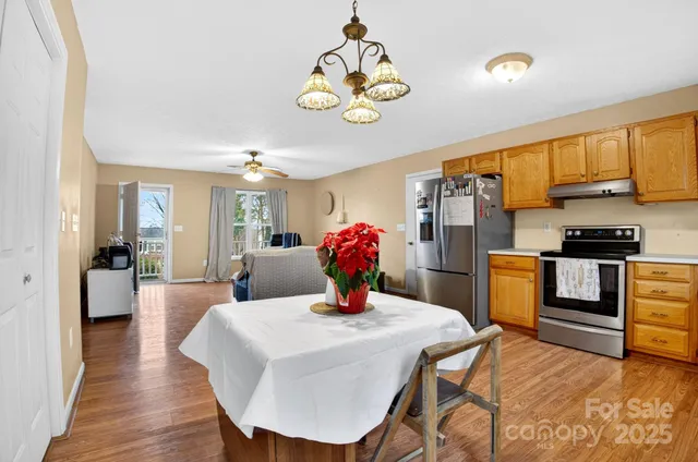 a kitchen with stainless steel appliances granite countertop a kitchen island a stove a dining table and chairs