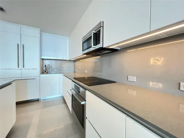 a kitchen with granite countertop a sink and a stove top oven