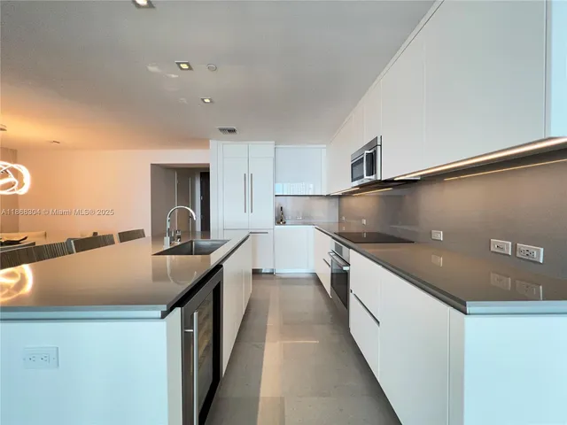 a kitchen with kitchen island a sink a stove and a refrigerator