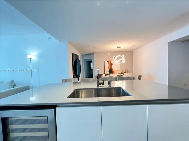 a kitchen with kitchen island a sink and a stove with wooden floor