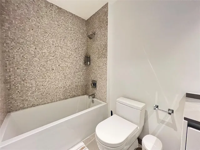 a white toilet and tub sitting next to a bathroom sink
