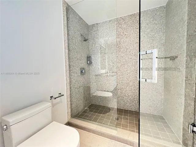 a bathroom with a toilet and a shower