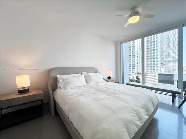 a large bed sitting in a bedroom next to a window