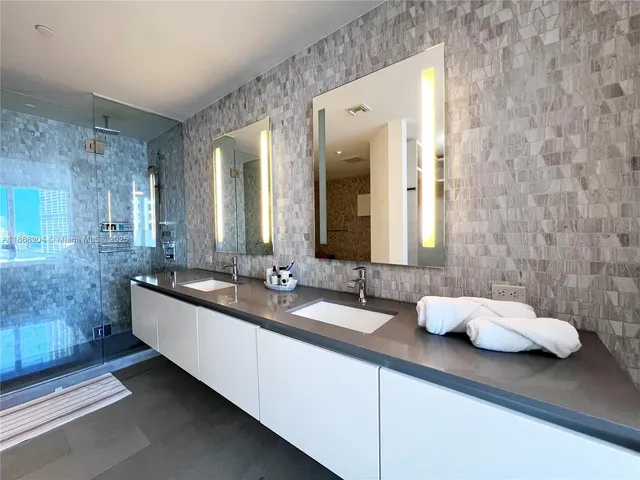 a bathroom with a double vanity sink and a mirror